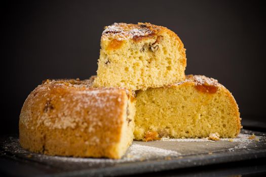 cooked sweet biscuit with dried apricots and nuts inside on a wooden table
