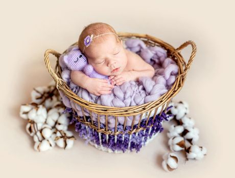 Funny little new born girl hugging teddy bear, close up