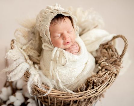 Cute sleeping newborn baby girl in the basket