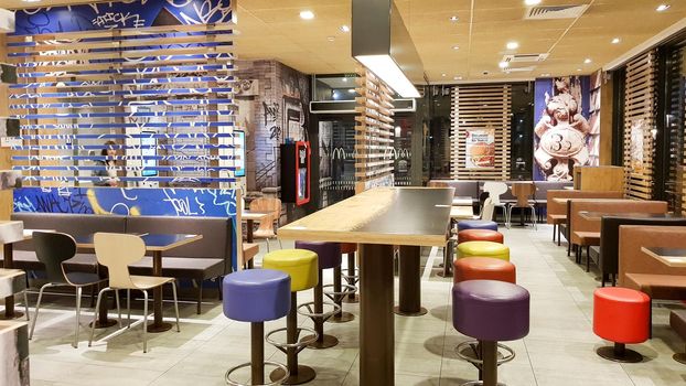 Ukraine, Kiev - August 19, 2019: McDonald's restaurant interior. McDonald's is the world's largest fast food restaurant chain based in the USA. Interior with tall tables and colored bar stools.