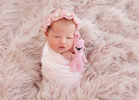 newborn baby girl sleeping sweetly with a small toy