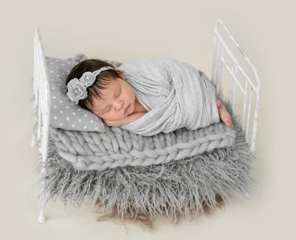 cute newborn baby girl sleeping in a little bed