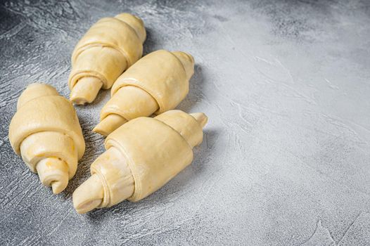 Raw unbaked croissant on kitchen table. White background. Top view. Copy space.