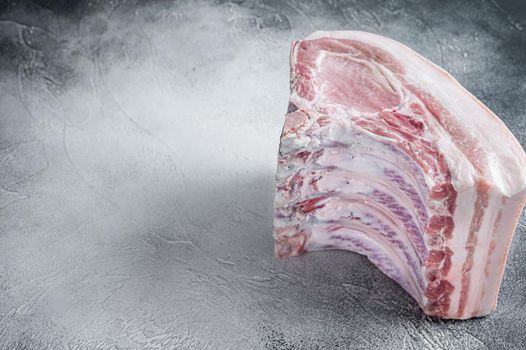 Raw whole rack of pork loin with ribs on kitchen table. White background. Top view. Copy space.