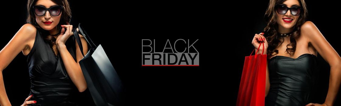 Beautiful young woman make shopping in black friday holiday. Girl with black bag on dark background.