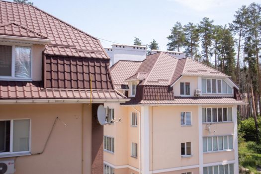 Roof on residential property with new brown corrugated metal roof tiles. Modern metal roof. Metal roofing