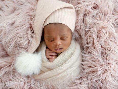 Newborn African sleeping baby in hat