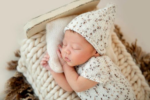 Dreamy newborn baby sleeping peacefully on the side on bed