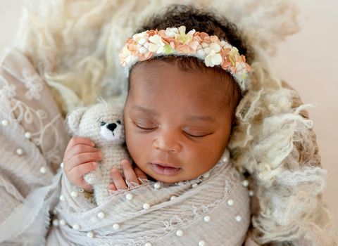 African sleeping baby holding toy in little hands