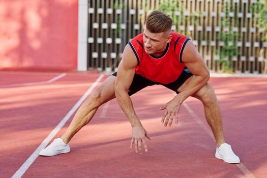 athletic man doing exercises outdoors sports field exercise. High quality photo