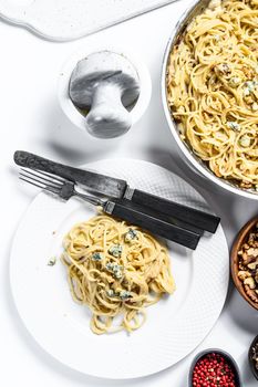 Spaghetti pasta with blue Gorgonzola cheese sauce. White background. Top view.