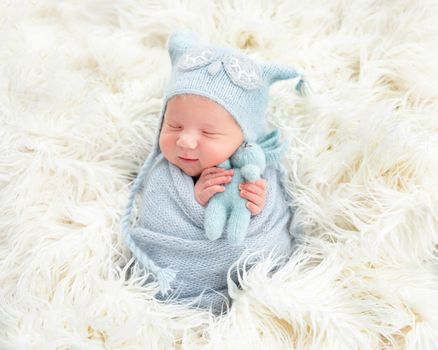 Cute newborn in blue knitted suit