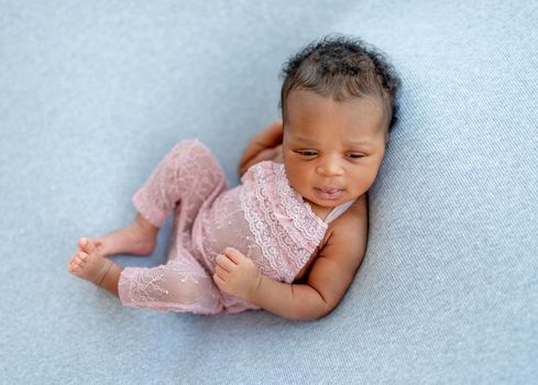 Cute African newborn baby girl posing in nice suit