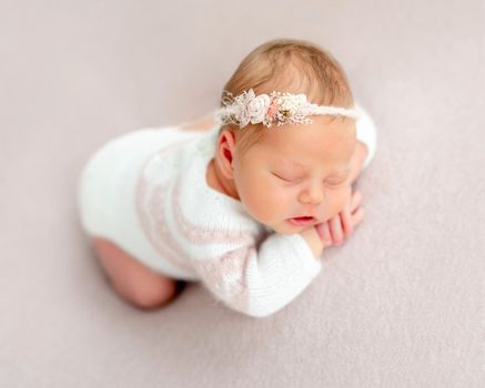 Beautiful newborn baby in floral diadem dreaming