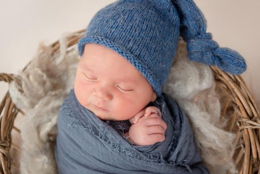 Lovely newborn boy sleeping in basket