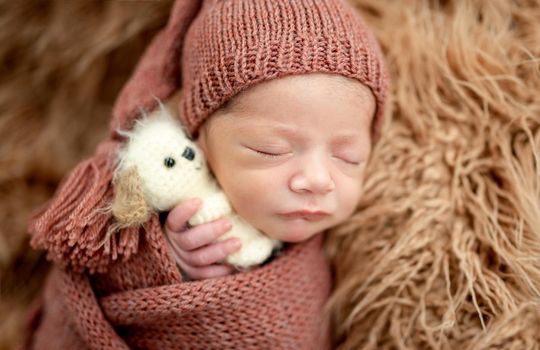 Charming newborn wrapped up in knitted blanket