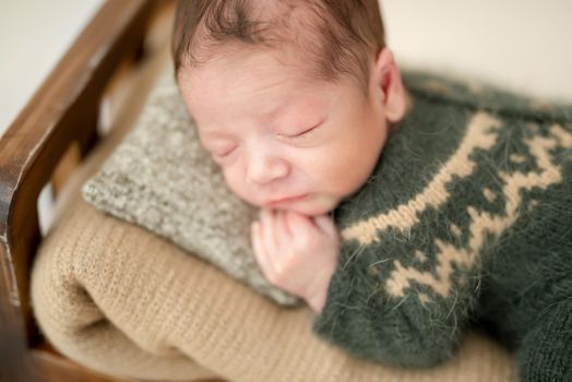 Lovely newborn sleeping on tiny bed