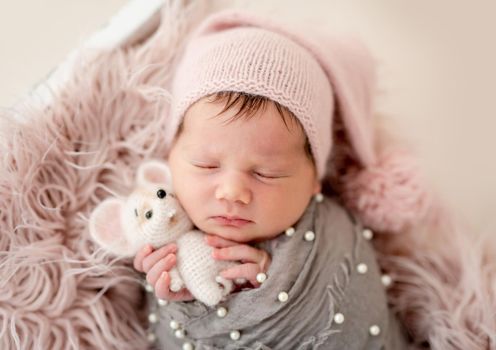 Cute newborn with toy in tiny hands