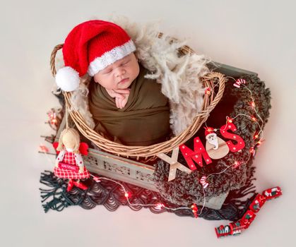 Lovely newborn wearing santa hat in christmas decorations