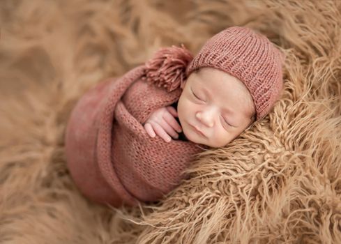 Charming newborn wrapped up in knitted blanket