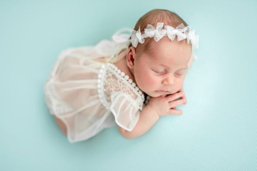 Charming newborn angel in white clothes
