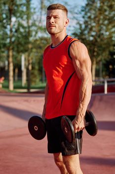 Muscled Man With Dumbbells Outdoor Workout. High quality photo