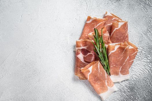 Italian prosciutto crudo parma ham on a table. White background. Top View. Copy space.