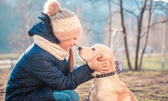 Cheerful girl having fun with adorable dog in park