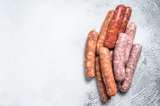 Assorted raw chorizo sausages. White background. Top view. Copy space.