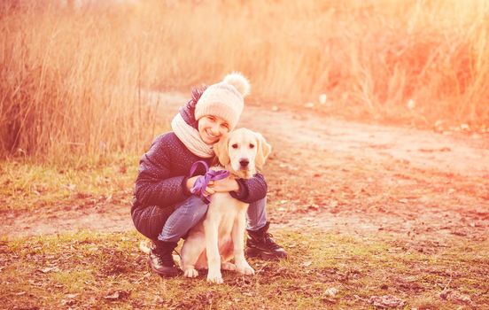 Cute girl with young dog in autumn park