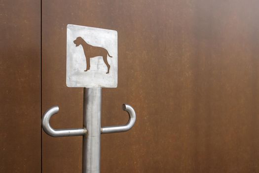 Close-up of an outdoor dog parking sign. A place for a leash for dogs waiting for their owners on the street. Attach a leash, in public places or at the entrance to the store. Copy space