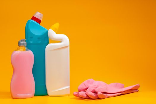 House cleaning detergent bottles on a yellow background, copy space