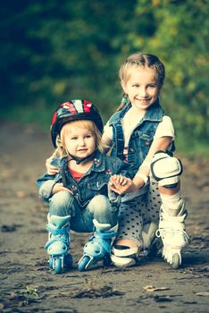 two sisters on roller skates in park