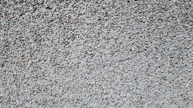 Pebbles Rubble In the cement courtyard. Dirty cracked old grunge vintage light gray concrete and cement mold texture wall or floor background with weathered paint and scratches.
