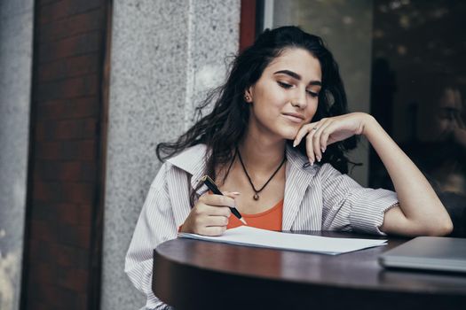 smile female student outdoor cafe in front of laptop business. High quality photo