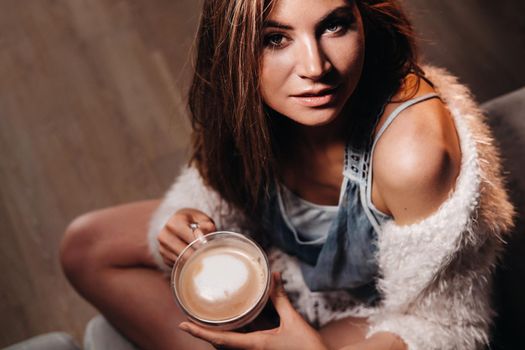 relaxed girl at home drinking coffee.Inner peace.The girl is sitting comfortably on the sofa and drinking coffee.