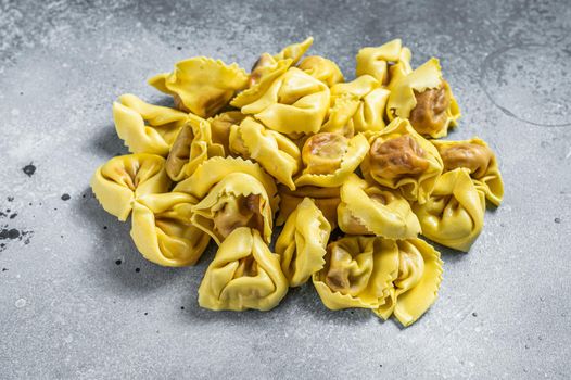 Uncooked raw ravioli with Mozzarella and Tomato. Gray background. Top view.