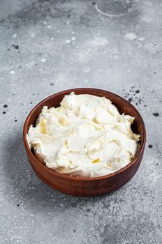 Traditional Mascarpone cheese in wooden bowl. Gray background. Top view.