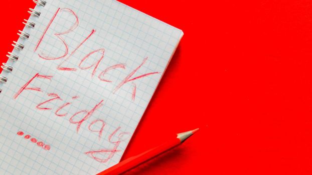 Black friday sale text written on a notepad with a red pencil on a red background. Background, holiday concept. Black Friday - International Day of Shopping, Promotions, Discounts, Sales. Sales season is the fourth Thursday of November. Copy space, place for text, flat lay.