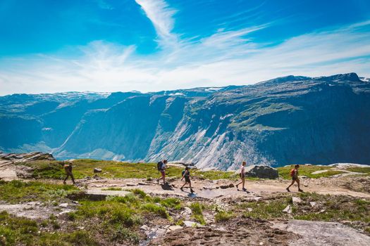 July 26, 2019. Norway tourist route on the trolltunga. People tourists go hiking in the mountains of Norway in fine sunny weather to thetrolltunga. Hiking backpack theme.