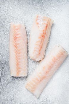 Raw Norwegian cod fish fillet on kitchen table. White background. Top view.