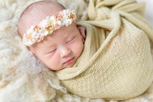 Lovely smile of a tiny little girl sleeping, wrapped up with a warm blanket