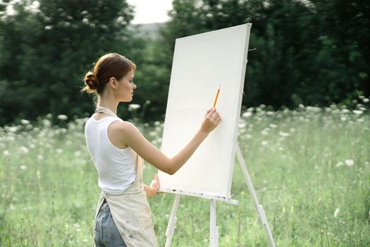 woman outdoors painting a picture creative art landscape. High quality photo