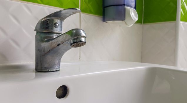 Old aluminum sink mixer. Water tap in the toilet for clean hands