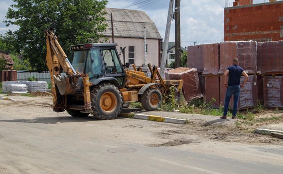 Excavator at a construction site. Heavy machinery at work. A large yellow construction vehicle at a construction site. Industrial image. Ukraine, Kiev - August 12, 2021