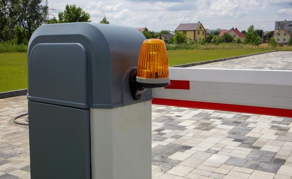 Close the gate. Automatic security system. Automatic entry system. Yellow light signal with a street barrier. Barrier gates Automatic security system