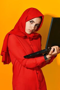 arab woman laptop posing technology internet yellow background. High quality photo
