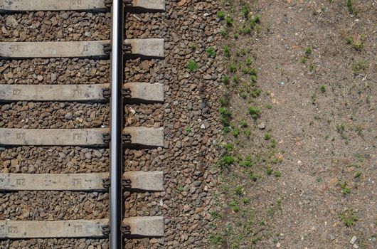 Railroad top view, flat lay. Part of the track for trains. Aerial view of a railway from a drone. Background with space for text. Shiny iron rails and concrete sleepers