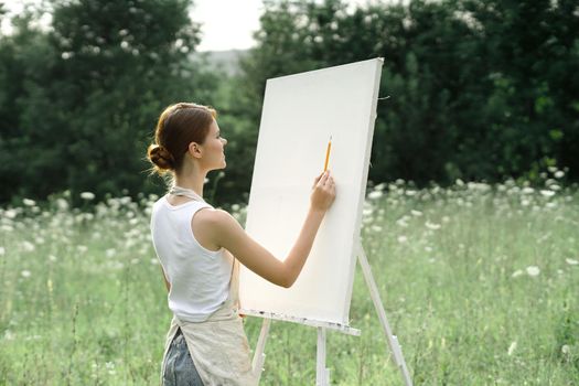 woman outdoors painting a picture creative art landscape. High quality photo