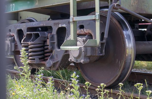 The undercarriage of the carriage with wheels and springs. Passenger train, freight train. Industrial railway wheels close up